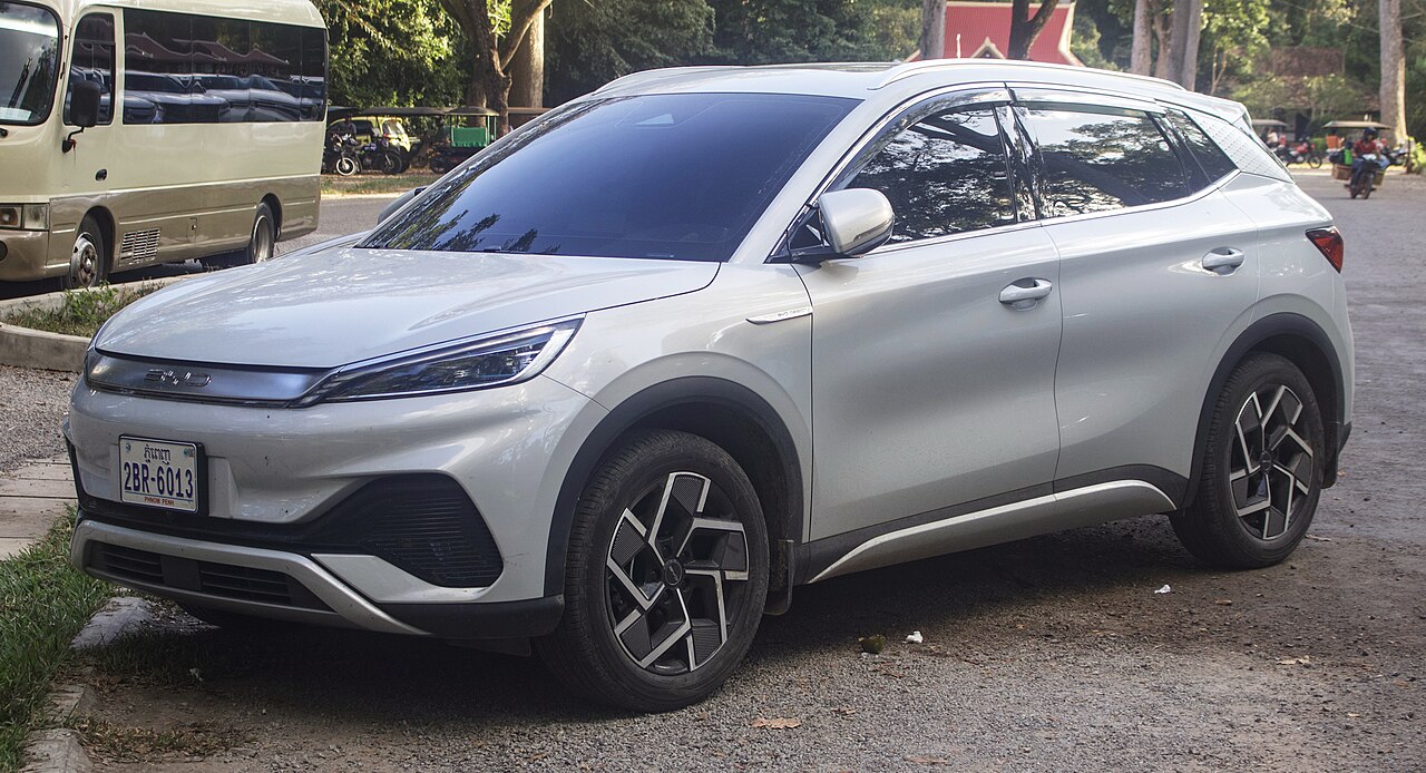 SUV eléctrico BYD Atto 3 en carretera con paisaje urbano