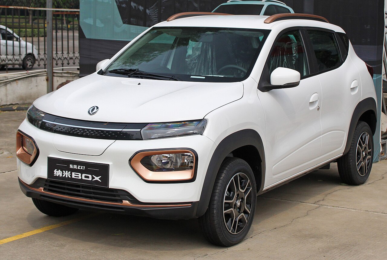 Coche eléctrico compacto urbano de color blanco aparcado en una calle