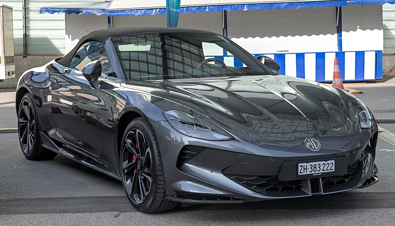 Deportivo roadster descapotable de color rojo en una carretera costera