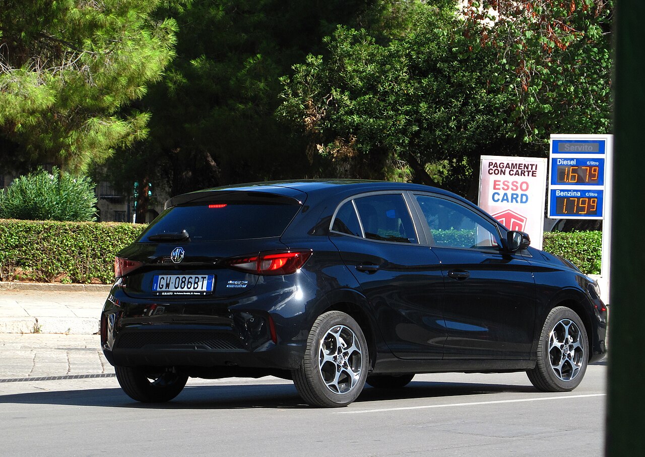 Coche compacto moderno de color rojo circulando por una carretera